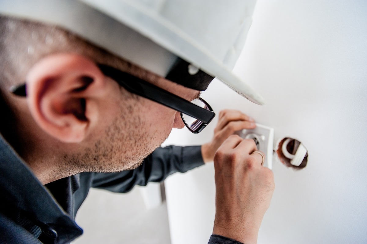An electrician repairing a wall socket