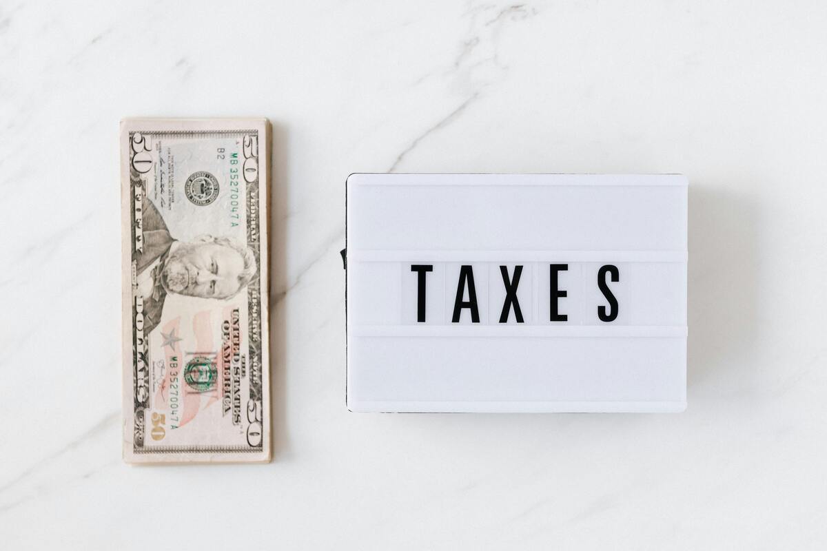 A cutout word about taxes with dollar bills