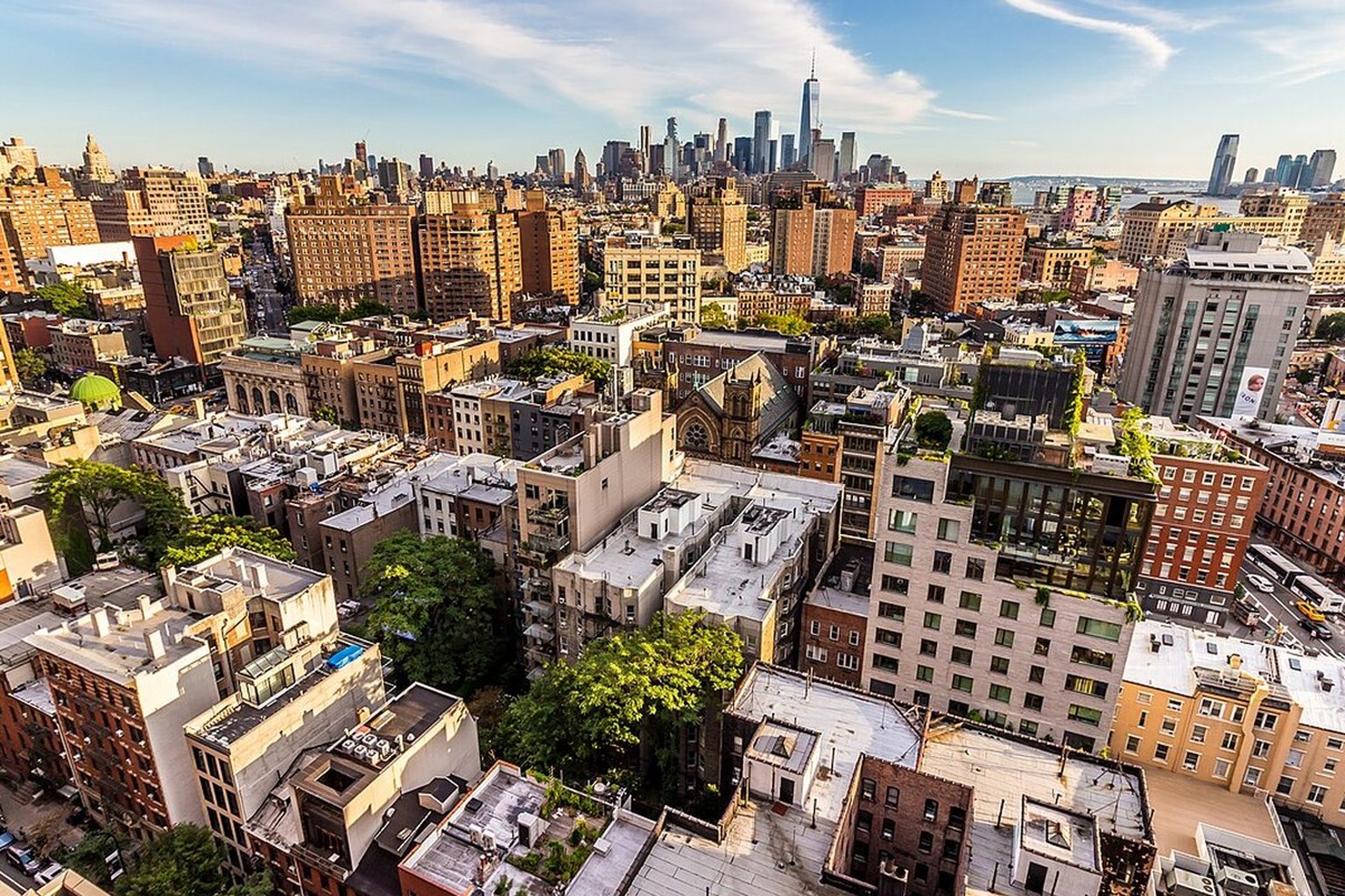 Aerial view of Greenwich Village in Manhattan with mid-rise residential buildings and the New York City skyline in the background