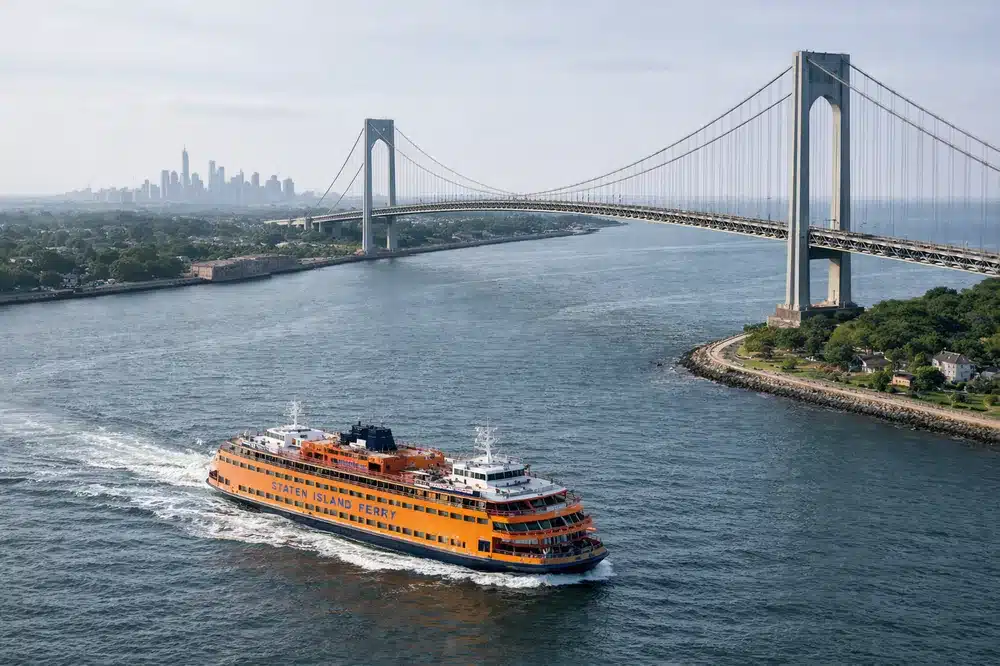 Aerial view of the Verrazzano-Narrows Bridge with a Staten Island Ferry crossing New York Harbor near Staten Island.
