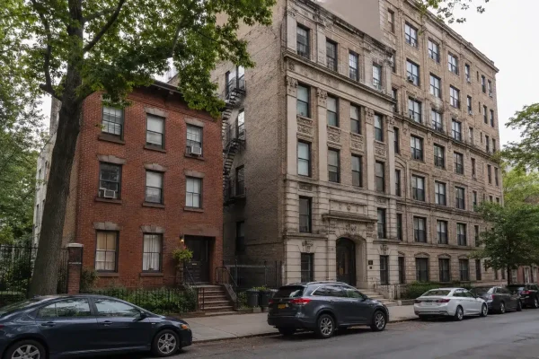 Two contrasting rent regulated apartment buildings side by side on a NYC block